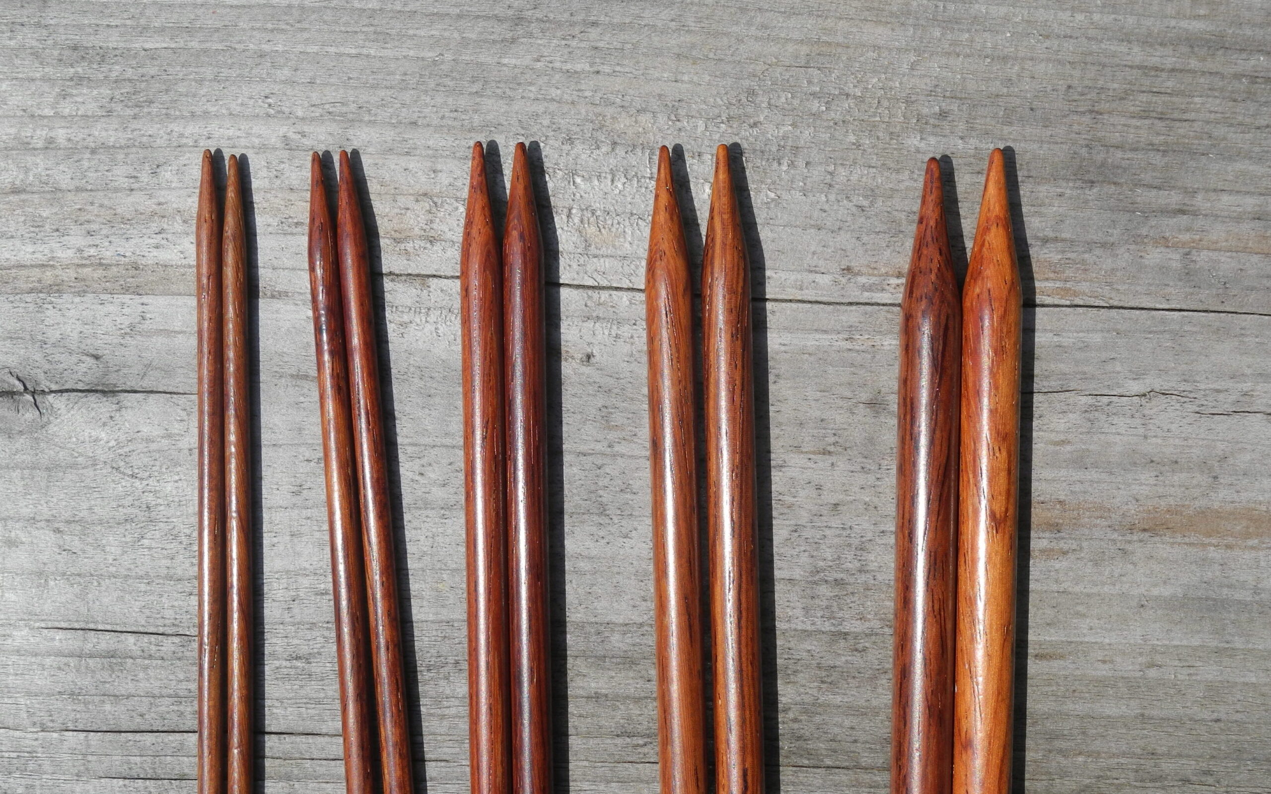 five sets of wood knitting needles ranging in sizes