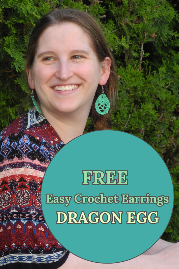 Woman smiling outside wearing green crochet earrings in dragon egg pattern