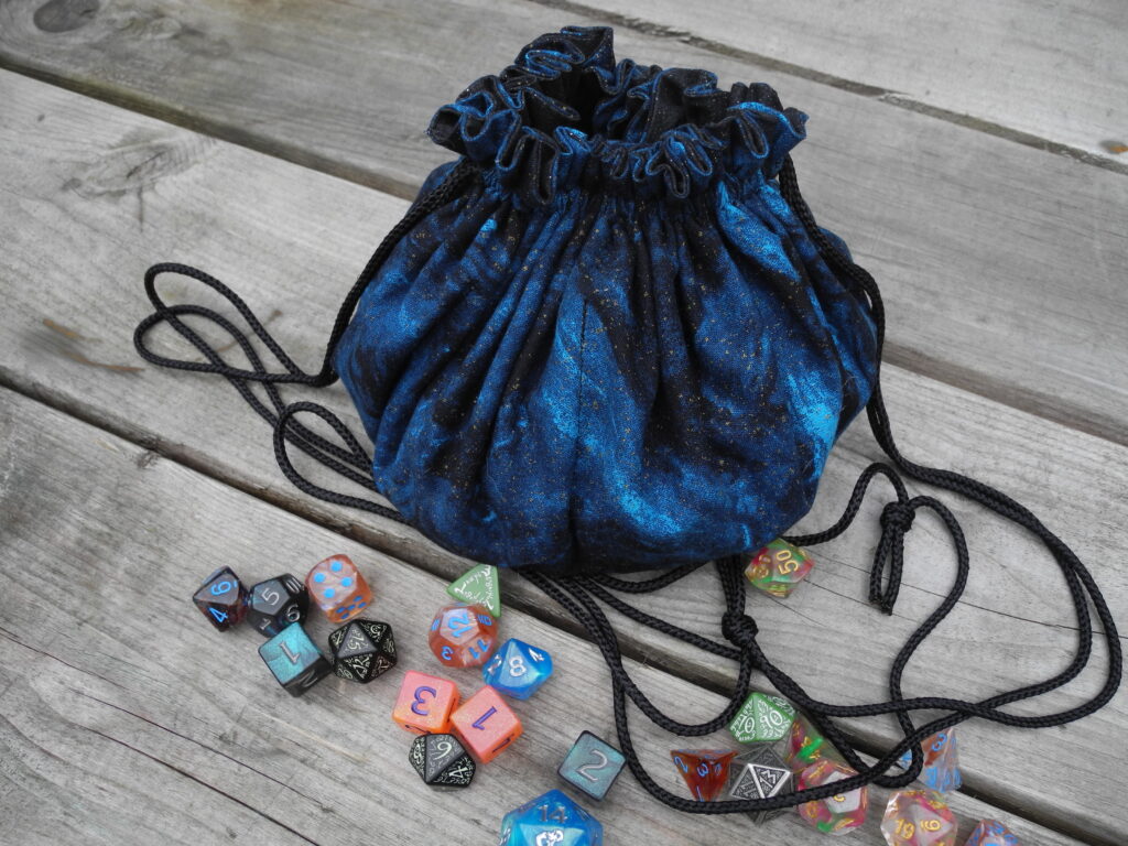 closed blue drawstring dice bag with multi color dice