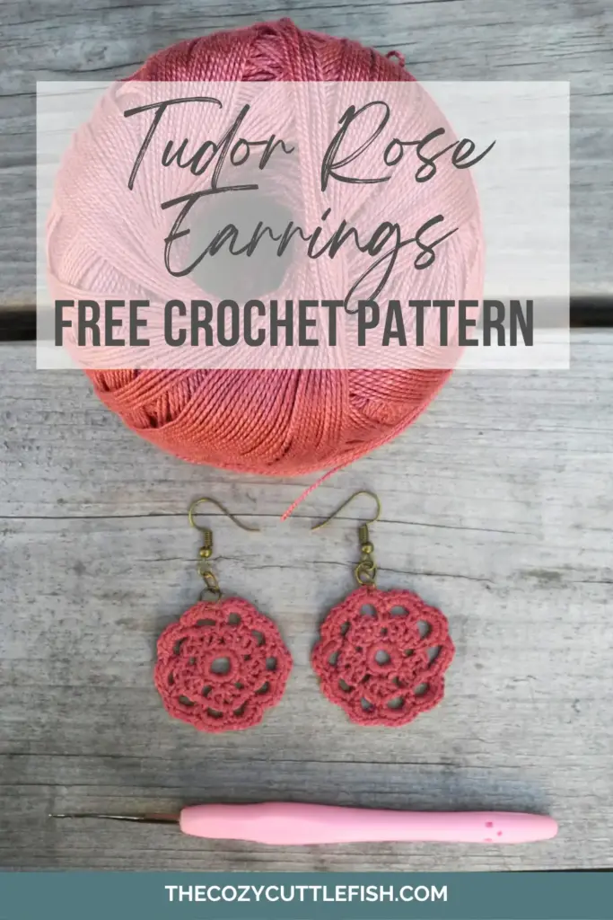 image shows top of a ball of pink yarn, a pair of pink tudor rose crochet earrings and a pink handled crochet hook. 