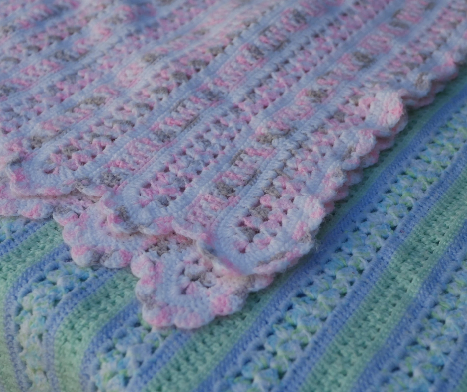 image of two striped crochet blankets made of variegated yarn with scalloped edges. Top blanked is made of white pink and brown yarn, bottom blanket is made of blue green and white yarn. 