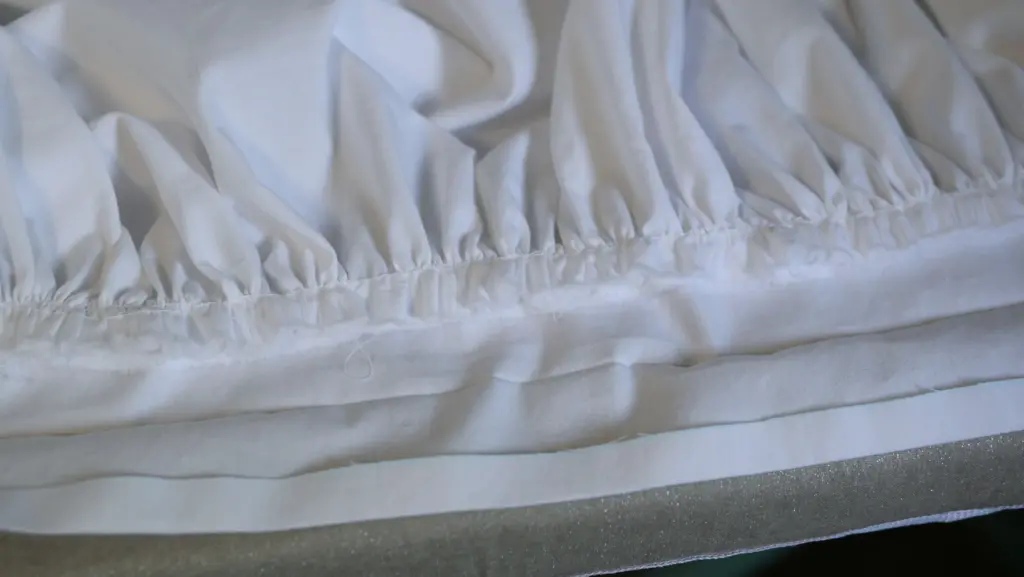 gathered edge of a white petticoat sewn onto one side of a waistband