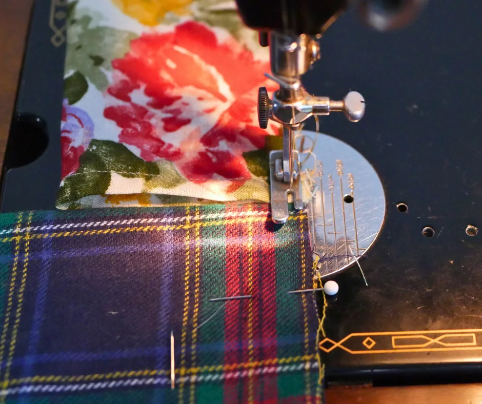close up of the foot of a sewing machine sewing a floral fabric, about to cross to a flannel fabric without stopping. 