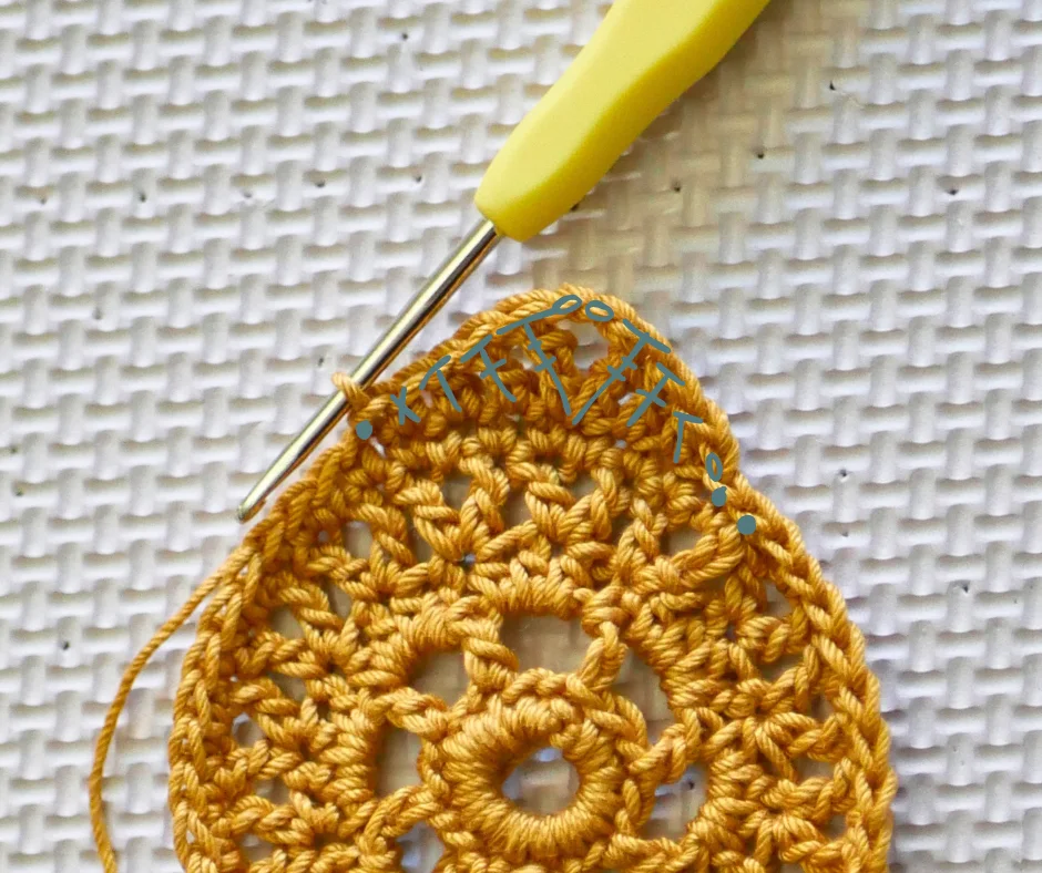Image of a crochet hook with yellow handle completing an equinox earring. Hand drawn symbols in teal show where to place the final stitches. 