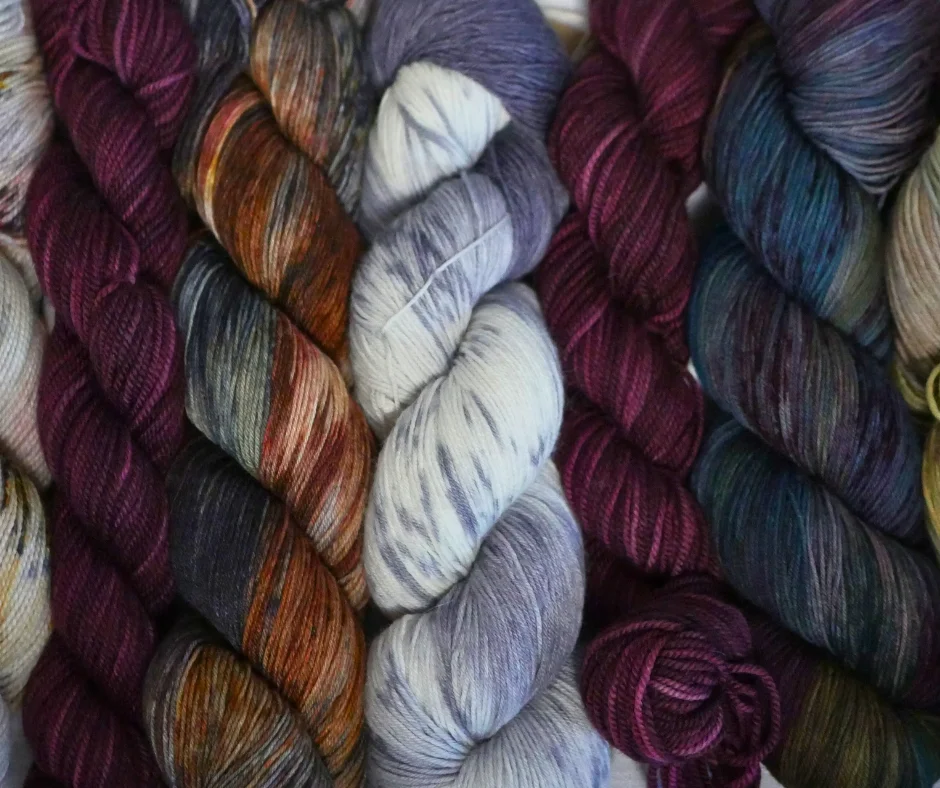 Image of a row of hanks of yarn with multicolor dyes. 