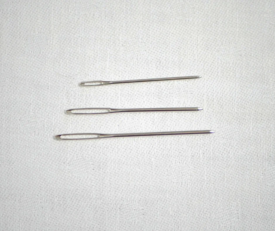 Image of three metal tapestry needles in different sizes. 
