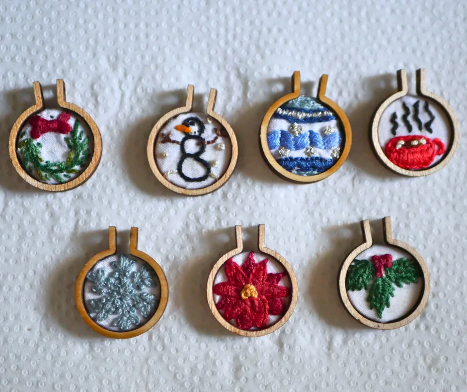 Image of seven mini embroidery designs with small embroidery hoops around them. 
