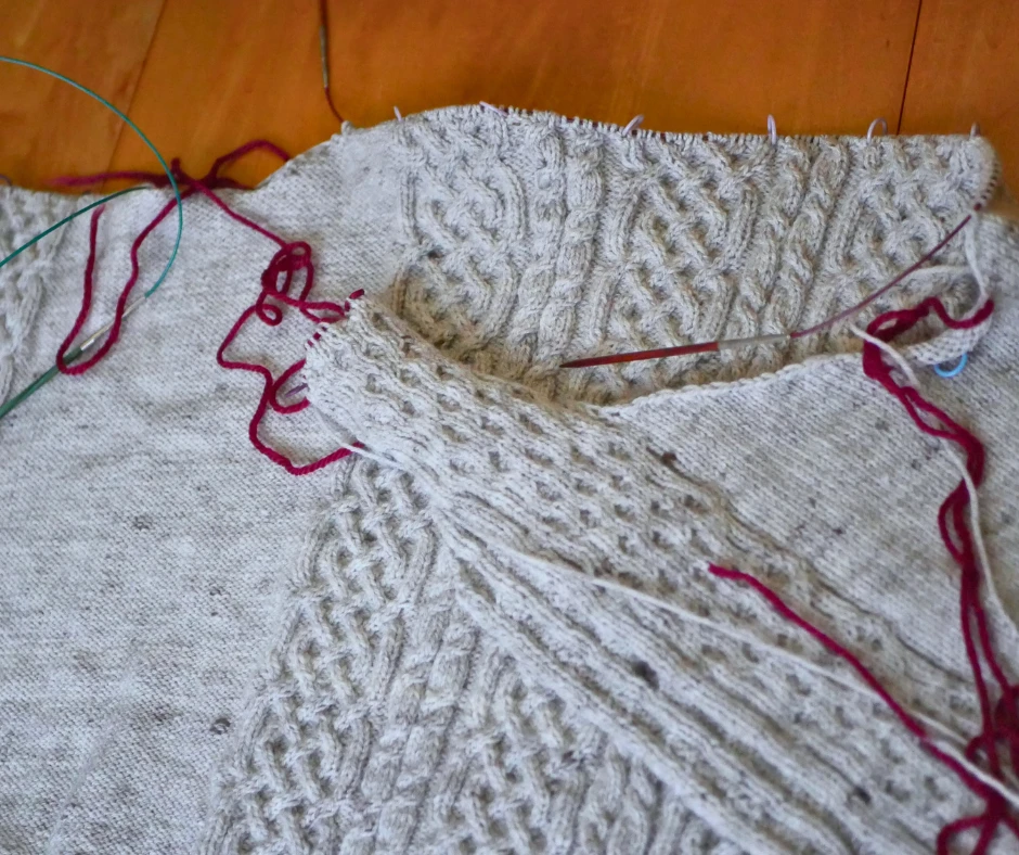 Image of a partially knit cabled cardigan. 