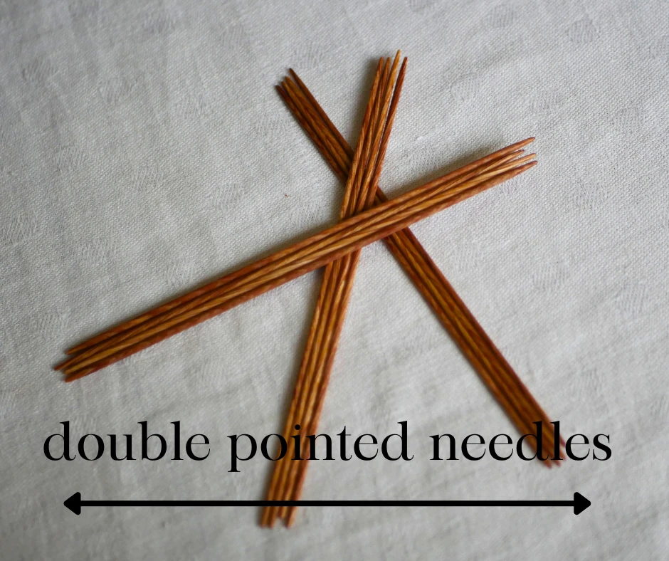 Image of three sets of wood double pointed needles labeled double pointed needles with a doubled ended arrow. 