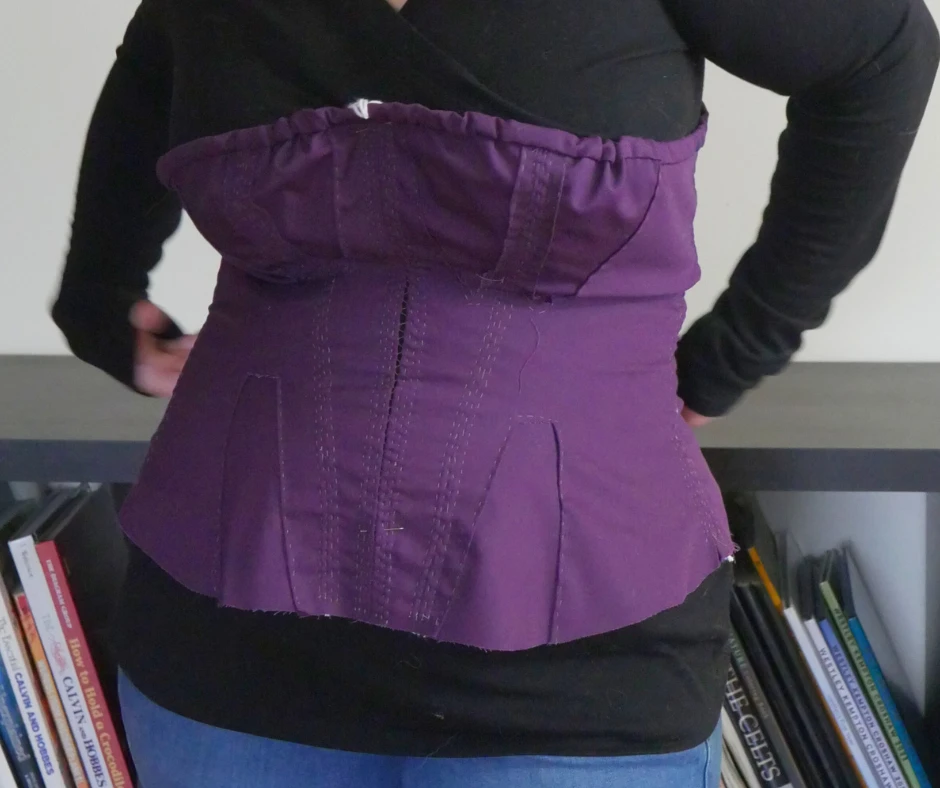 Image of a purple corded corset on a woman. 