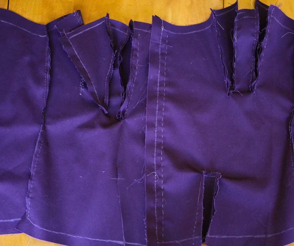 Image of the inside of a purple corset mockup with hastily hand stitching and poorly placed gores. 