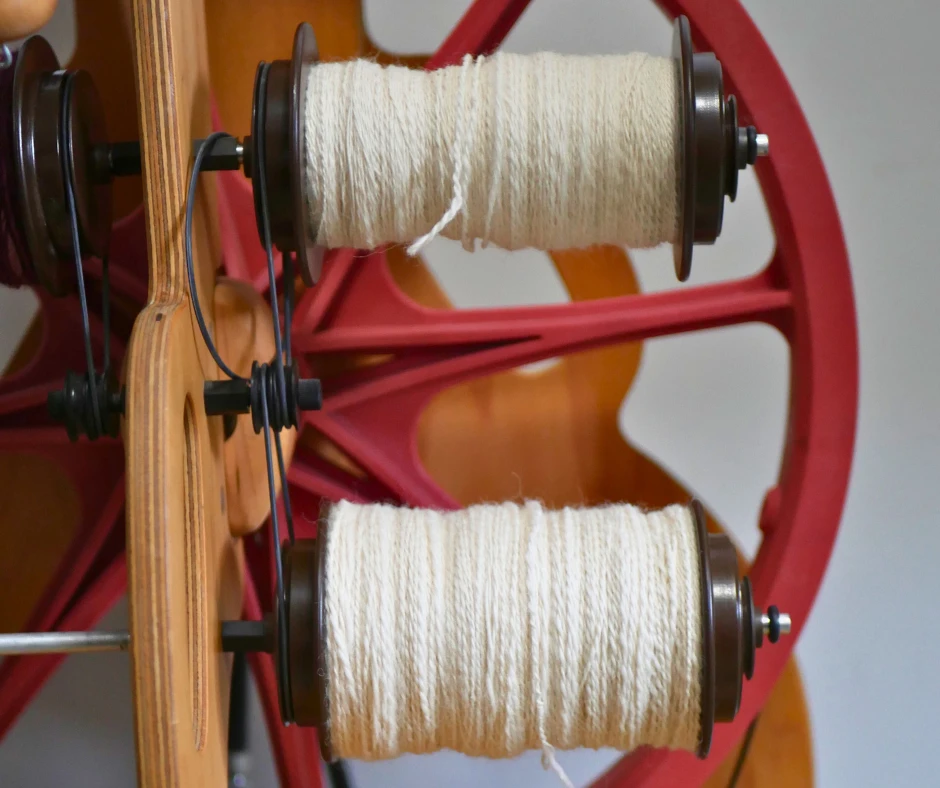 Image of the lazy Kate of a Schacht Ladybug spinning wheel with two bobbins full of two ply white yarn. 
