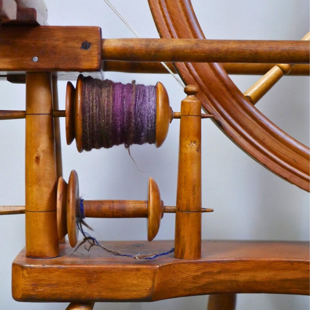 Image of the lazy Kate of a Norwegian spinning wheel with a bobbin full of freshly spun singles. 
