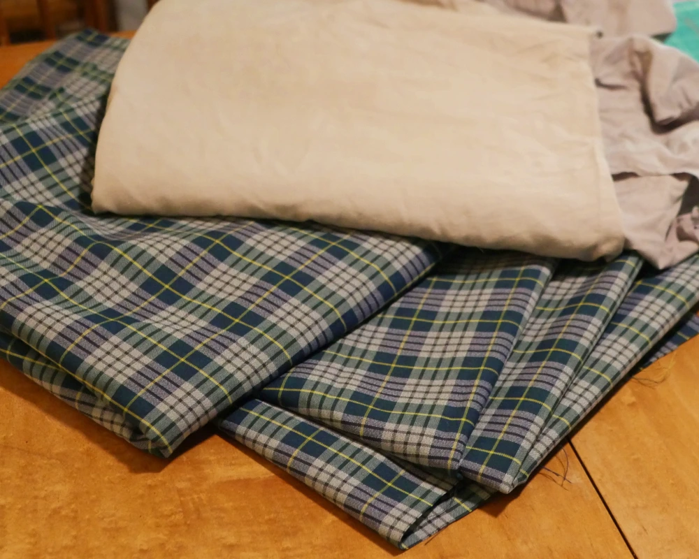 A small stack of folded, thrifted fabric. 
